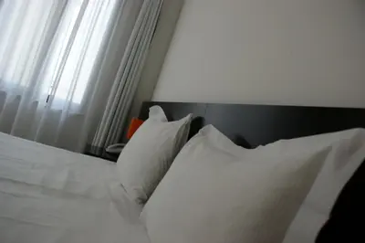 a bed with white pillows sitting next to a window at Hotel Aniene in Rome
