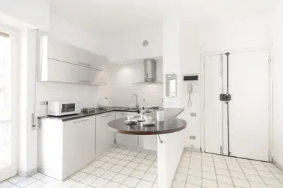 a white kitchen with a table and a microwave at Margaret Guest House in Rome