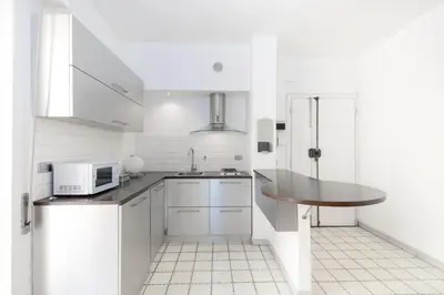 a white kitchen with a sink and a microwave at Margaret Guest House in Rome