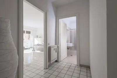 a white hallway with a door leading to a bathroom at Margaret Guest House in Rome