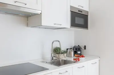 a kitchen with white cabinets and a sink at iFlat Vatican Modern & Comfortable Peaceful Gem in Rome