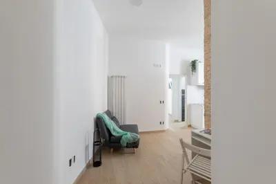 a living room with a chair and a table at iFlat Vatican Modern & Comfortable Peaceful Gem in Rome