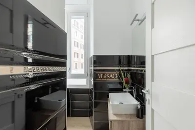 a bathroom with black and white walls and a sink at iFlat Vatican Modern & Comfortable Peaceful Gem in Rome