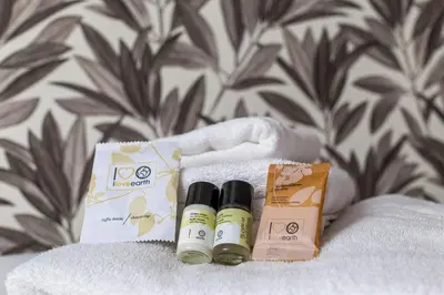 two bottles of essential oils and a box on a bed at iFlat Pantheon & La Dolce Vita Skyline Penthouse in Rome