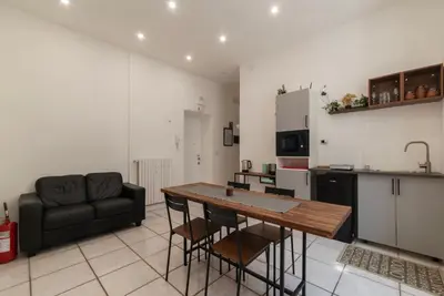 a kitchen and living room with a table and a couch at GuestHost - Metro Cipro-Ottaviano Apartment X6 in Rome