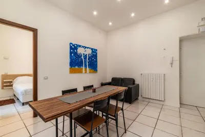 a living room with a wooden table and chairs at GuestHost - Metro Cipro-Ottaviano Apartment X6 in Rome