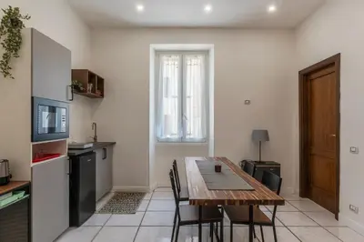 a kitchen and dining room with a table and chairs at GuestHost - Metro Cipro-Ottaviano Apartment X6 in Rome