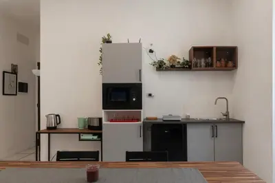 a kitchen with a white refrigerator and a stove top oven at GuestHost - Metro Cipro-Ottaviano Apartment X6 in Rome
