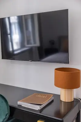 a book and a lamp on a table with a mirror at Suite23 , Roma in Rome