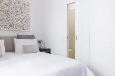 a bedroom with a white bed and a painting on the wall at Suite23 , Roma in Rome