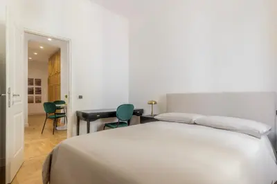 a bedroom with a white bed and two green chairs at Suite23 , Roma in Rome