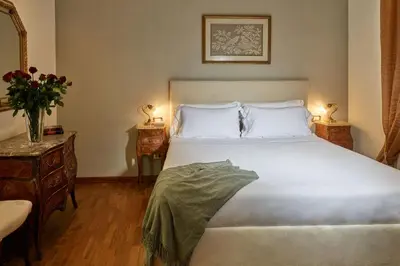 a bedroom with a large white bed with two lamps at TreasureRome Trevi Private Palazzo in Rome