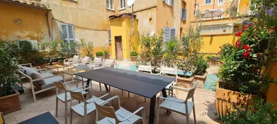 a patio with a table and chairs in a courtyard at TreasureRome Trevi Private Palazzo in Rome