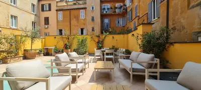 an outdoor patio with chairs and tables and buildings at TreasureRome Trevi Private Palazzo in Rome