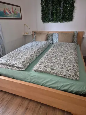 a large bed in a bedroom with a wooden frame at La casetta di Laura al Gemelli-Vaticano in Rome
