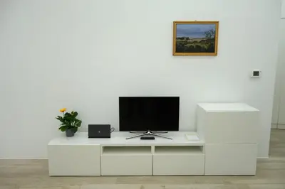a white entertainment center with a flat screen tv on it at Art & Garden Gemelli - Metro A - Vaticano in Rome
