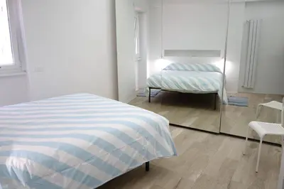a bedroom with a bed and a chair and a mirror at Art & Garden Gemelli - Metro A - Vaticano in Rome