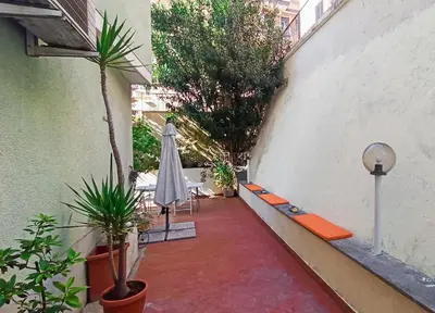 a courtyard with an umbrella and a table and chairs at Art & Garden Gemelli - Metro A - Vaticano in Rome