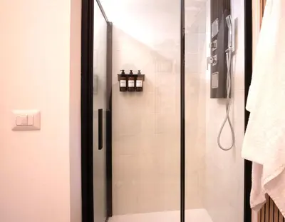a shower with a glass door in a bathroom at Bianca Guest House in Rome