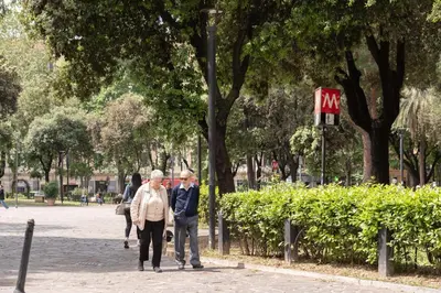 two people walking down a sidewalk in a park at Bianca Guest House in Rome