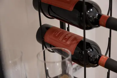 a bunch of bottles of wine hanging from a rack at Bianca Guest House in Rome