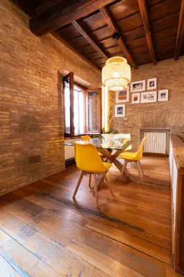 a dining room with a table and yellow chairs at Pantheon Private Apartment in Rome