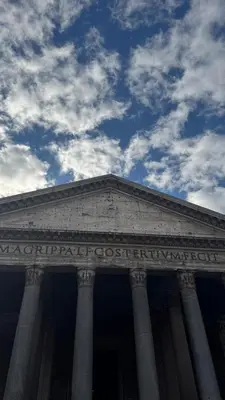 a large building with a cloudy sky in the background at Pantheon Private Apartment in Rome
