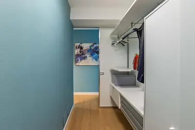 a hallway with blue walls and white shelves at Albertahaus in Rome