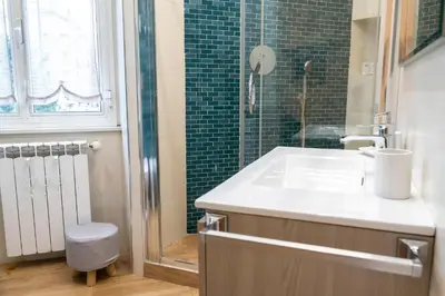 a bathroom with a sink and a shower with green tiles at Licia House - Intero Appartamento - San Giovanni in Rome