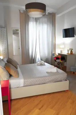 a bedroom with a white bed with a desk and a window at Licia House - Intero Appartamento - San Giovanni in Rome