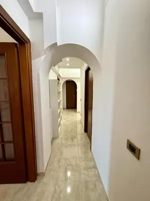 a hallway in a building with white walls and an archway at SanLo Nest in Rome