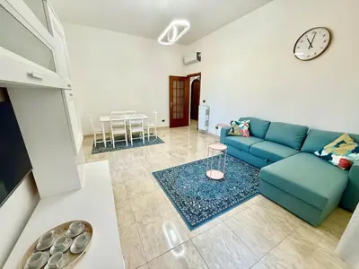 a living room with a blue couch and a clock at SanLo Nest in Rome