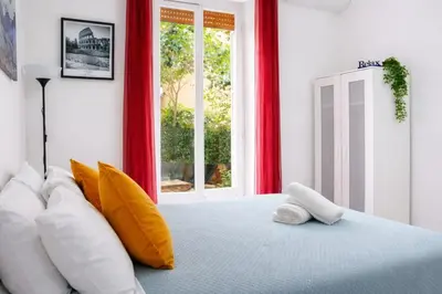 a bedroom with a bed with pillows and a window at Cozy Home Medaglie d'Oro in Rome