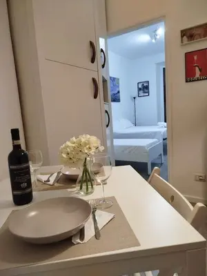 a table with a bottle of wine and two glasses at Cozy Home Medaglie d'Oro in Rome