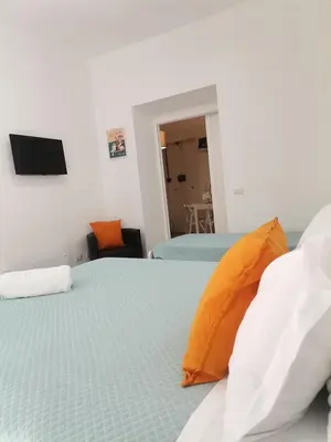 a bedroom with two beds with an orange pillow at Cozy Home Medaglie d'Oro in Rome