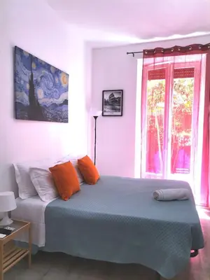 a bedroom with a bed with orange pillows and a window at Cozy Home Medaglie d'Oro in Rome
