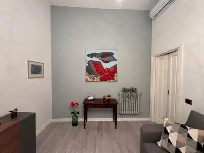 a living room with a table and a painting on the wall at Casa Amorello - Vaticano in Rome