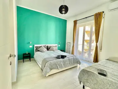 a bedroom with two beds and a blue wall at Casa Vacanze Jenner in Rome