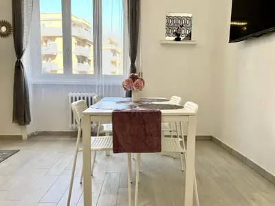 a white dining room table with white chairs and a table at Casa Vacanze Jenner in Rome