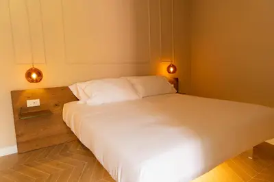 a room with a bed and a table with a bottle of wine at Gv Suite Collection - San Pietro Dome in Rome