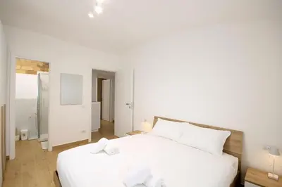 a white bedroom with a large white bed with white pillows at HC - Pigneto Cozy & Modern Retreat in Rome