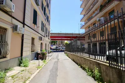 an alley between two buildings with a bridge in the background at HC - Pigneto Cozy & Modern Retreat in Rome
