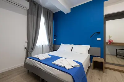 a blue bedroom with a bed with two towels on it at Suemy Rome B&B in Rome