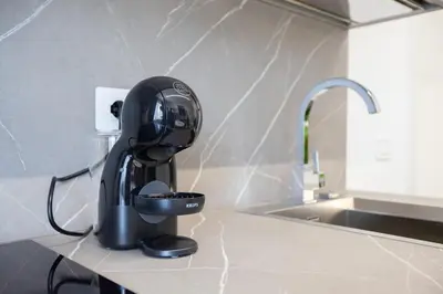 a black coffee maker sitting on a counter next to a sink at Suemy Rome B&B in Rome