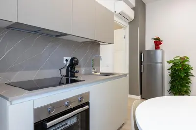 a kitchen with a sink and a stainless steel refrigerator at Suemy Rome B&B in Rome