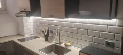 a kitchen with a sink and white tiles on the wall at Studio Flat Rome Metro Garbatella in Rome
