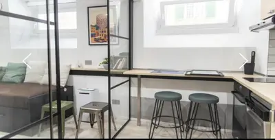 a small kitchen with two stools and a desk in a room at Studio Flat Rome Metro Garbatella in Rome