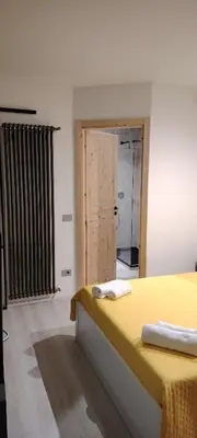 a bedroom with a yellow bed and a bathroom at Studio Flat Rome Metro Garbatella in Rome