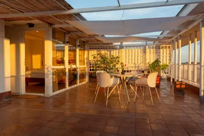 a patio with a table and chairs on a balcony at San Giovanni Rooftop in Rome