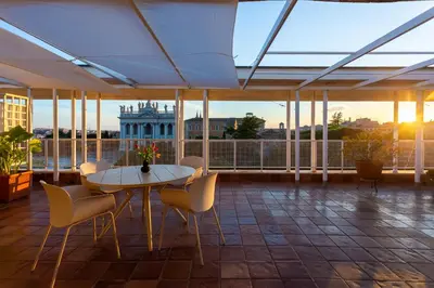 a balcony with a table and chairs and a building at San Giovanni Rooftop in Rome